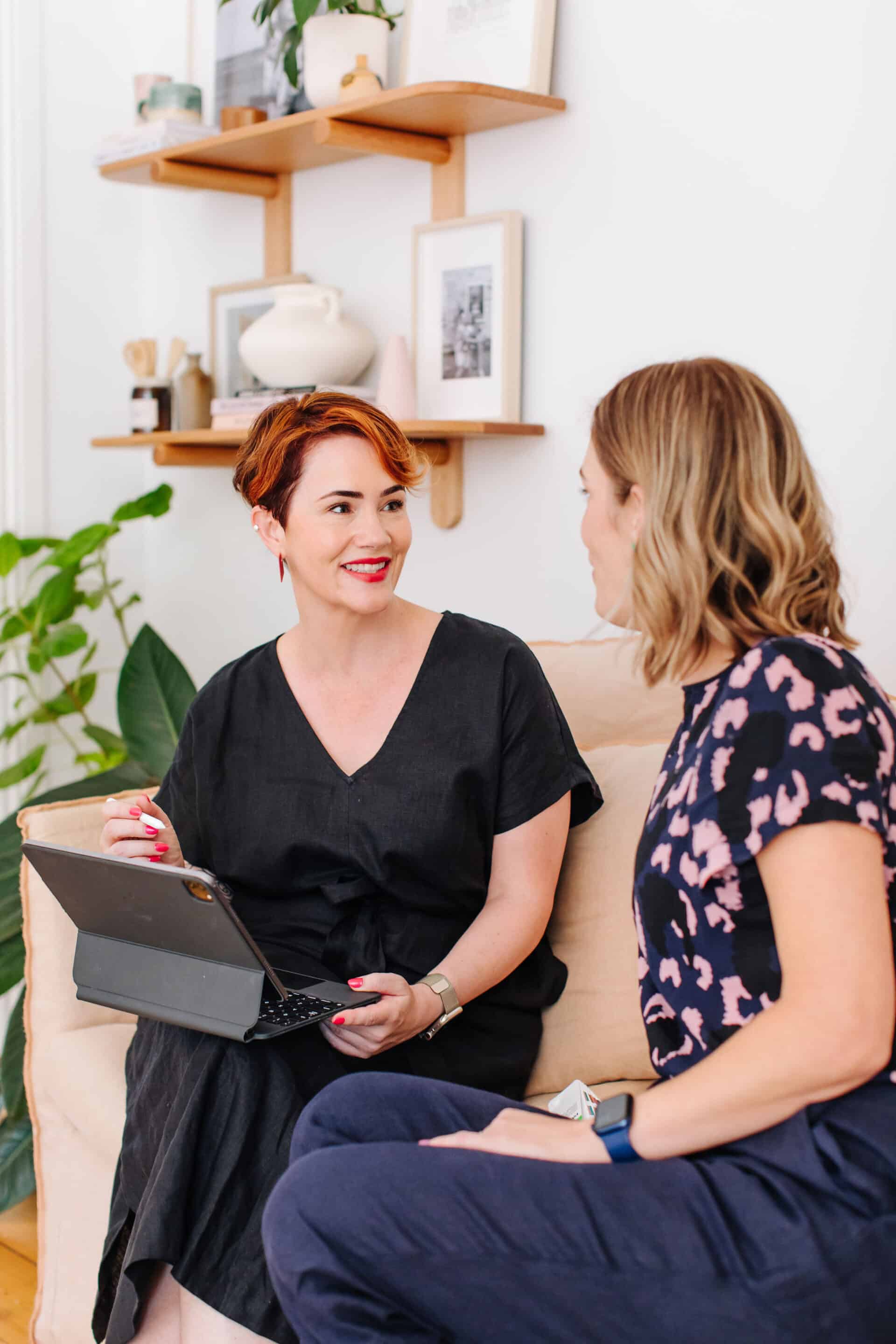 Kate Hall sitting on a couch talking to a client