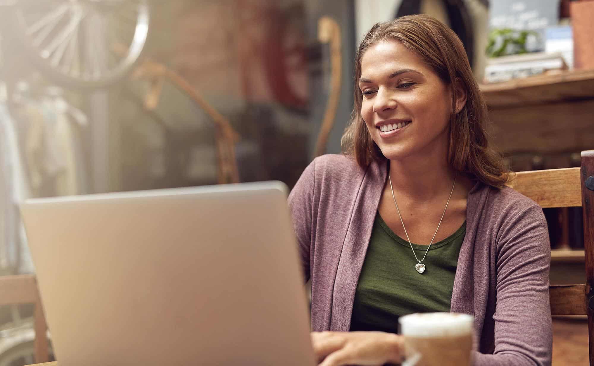 Woman, laptop and work in coffee shop of bike repair store with internet search and email. Morning, computer and small business owner with digital, cafe and website update for online company page.